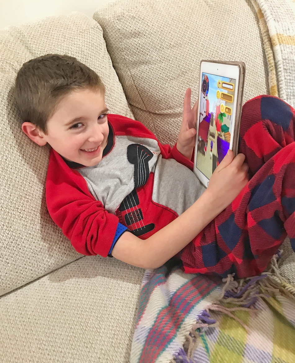 Boy playing Mightier app - boy showing iPad smiling