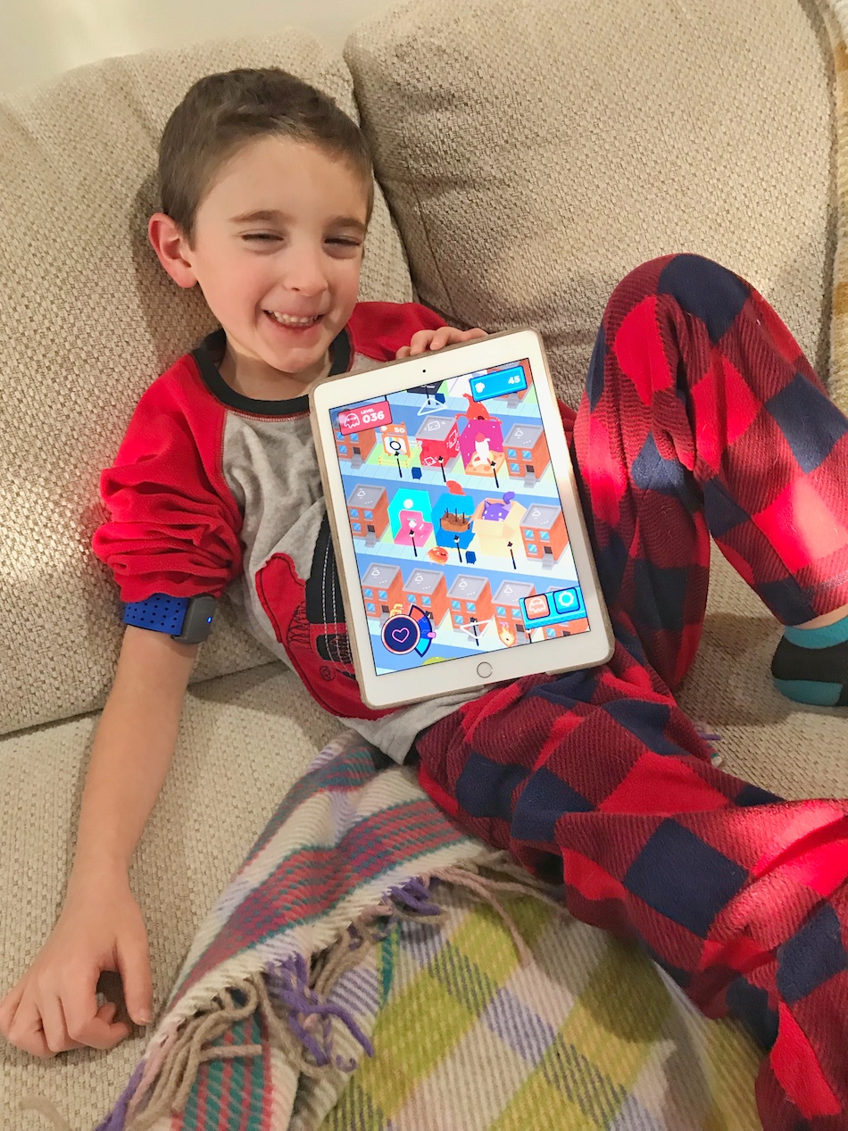 Boy playing Mightier app - boy smiling with app home open